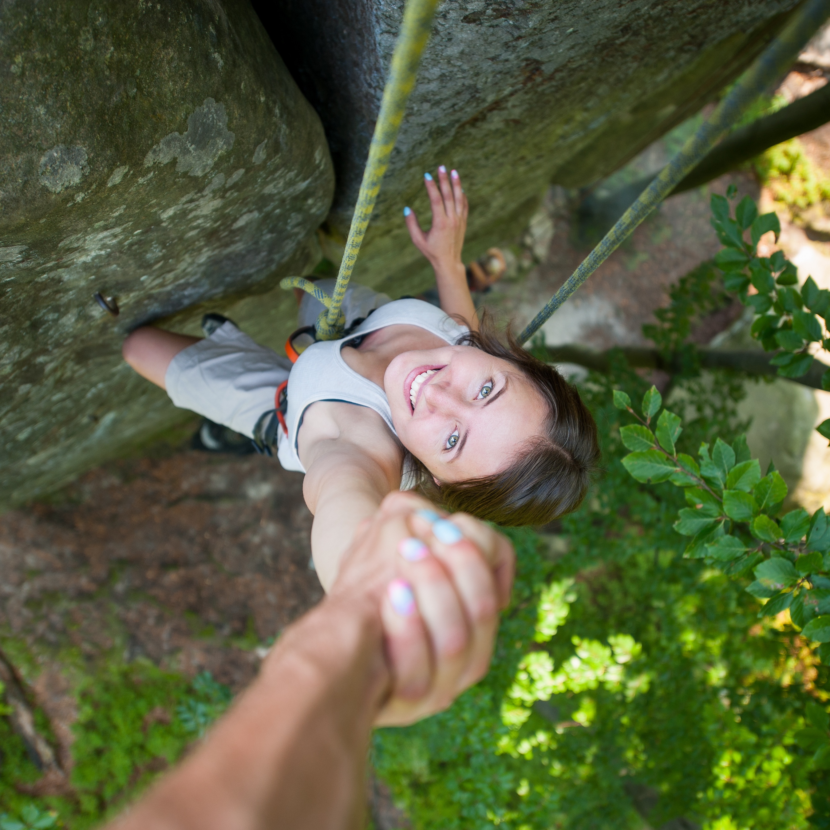 rockclimber helping to female climber